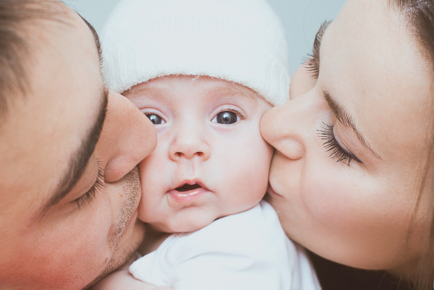 kleiner Familien-Kuss - das Baby als Mittelpunkt