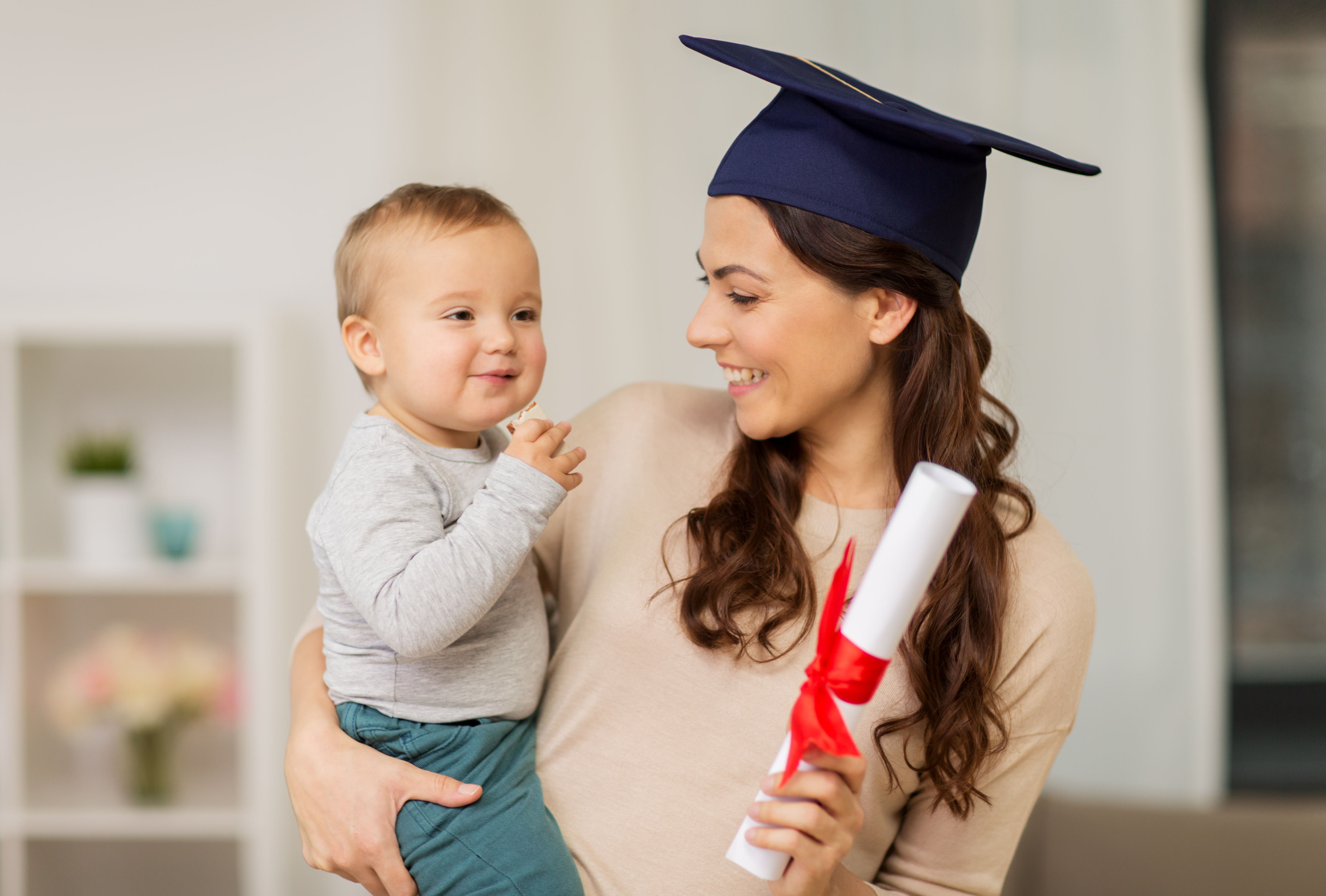 Junge Mutter und Baby Schule Abschluss 