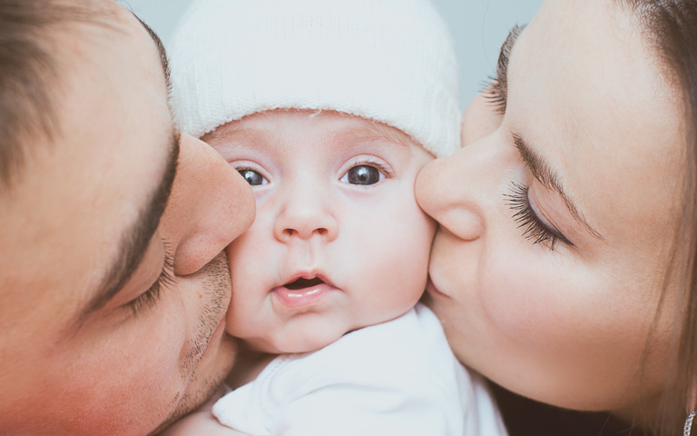 kleiner Familien-Kuss - das Baby als Mittelpunkt