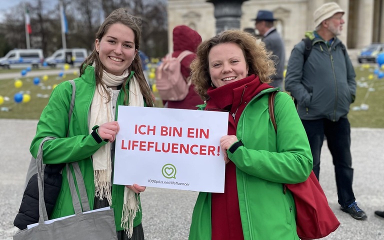 zwei 1000plus-Mitarbeiterinnen auf dem Münchner "Marsch für das Leben" mit einem "Ich bin ein Lifefluencer"- Plakat