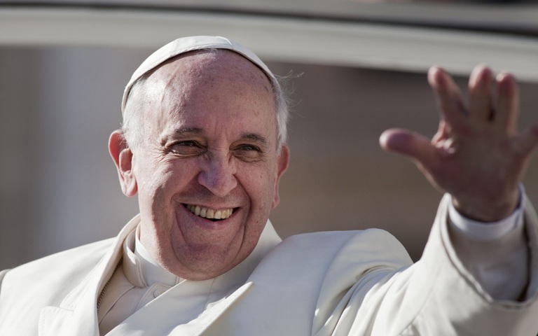 Papst Franziskus winkt der Menge lächelnd zu