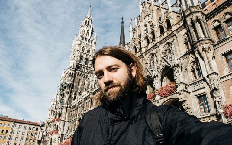 ein junger Mann macht ein Selfie auf dem Münchner Marienplatz