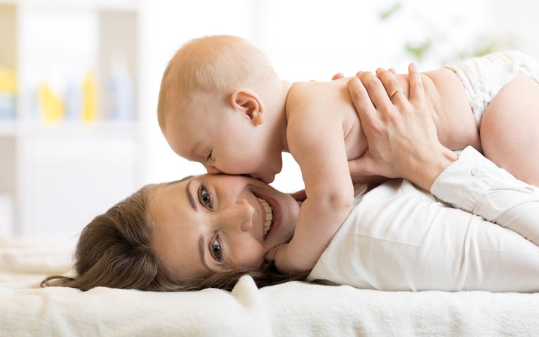 Zeit zu zweit: ein Baby gibt seiner Mama einen dicken Kuss
