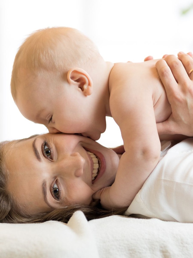 Zeit zu zweit: ein Baby gibt seiner Mama einen dicken Kuss