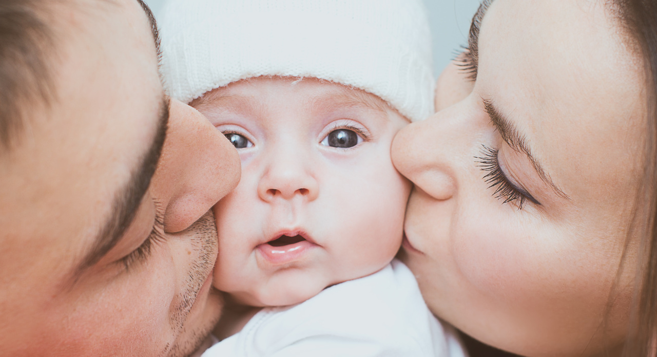 kleiner Familien-Kuss - das Baby als Mittelpunkt