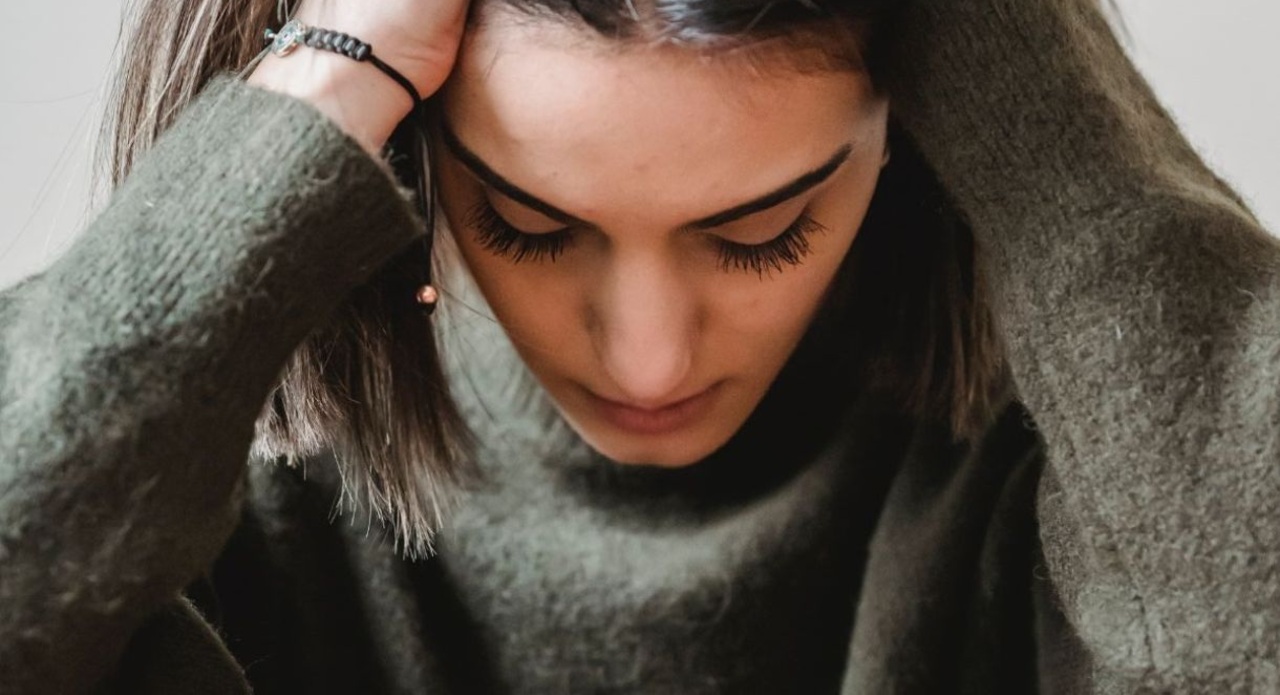 eine junge Frau rauft sich vor Verzweiflung die Haare
