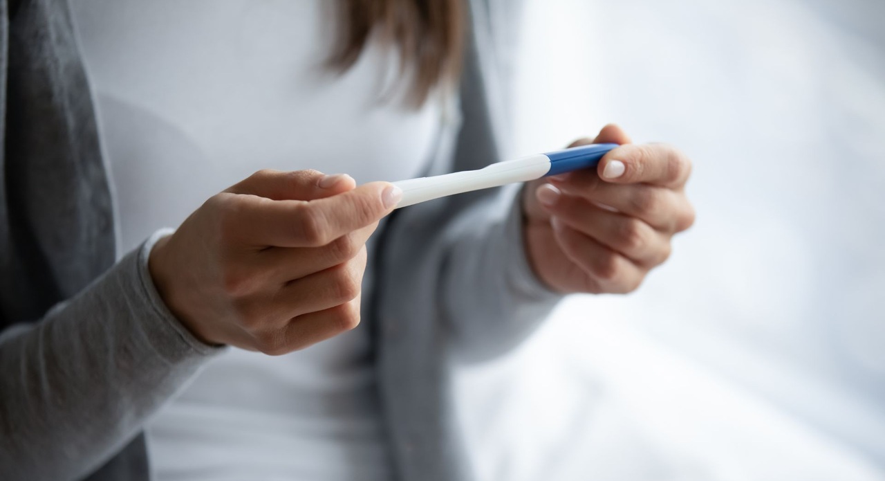 eine Frau hält einen Schwangerschaftstest in den Händen