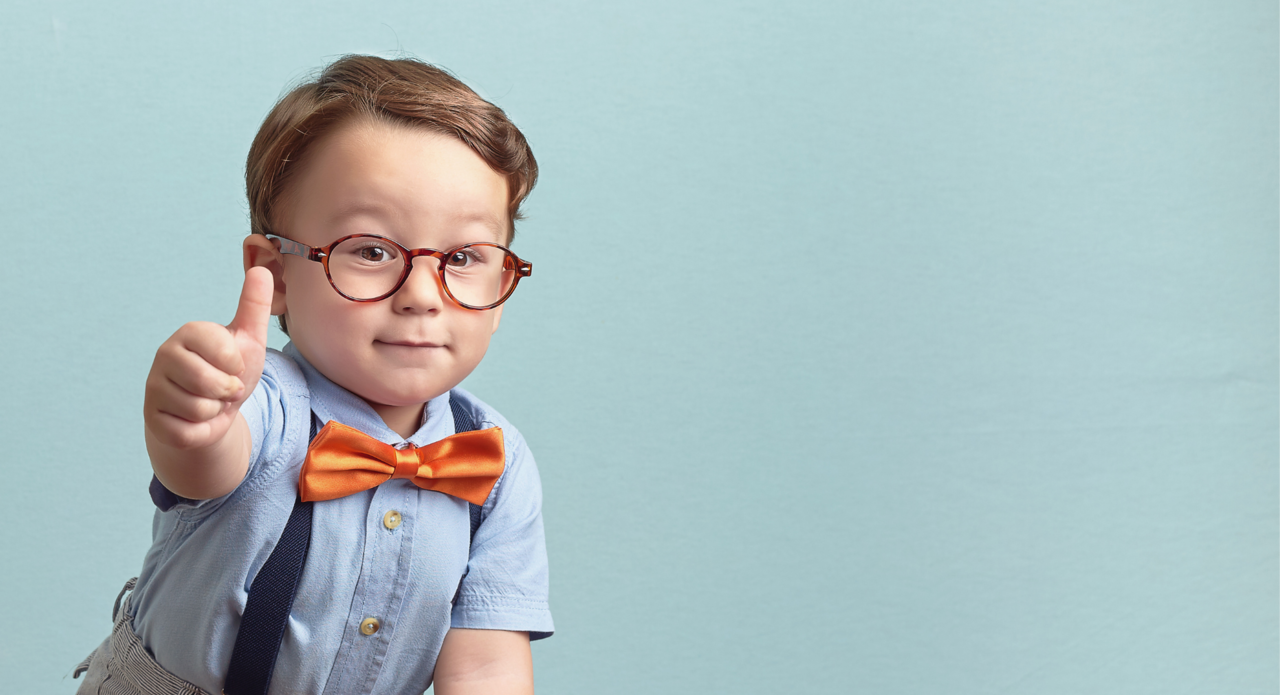100% Garantie - versichert ein kleiner Junge mit Brille, Fliege, Hosenträgern und Daumen hoch