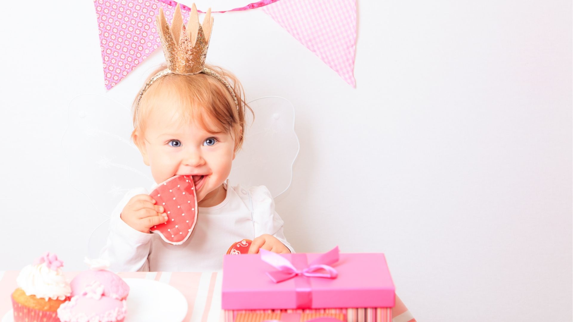 Eine kleine Geburtstags-Prinzessin knabbert an ihrem Geburtstagskuchen