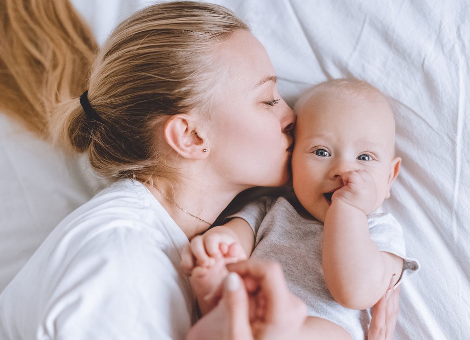 junge Mutter küsst ihr Baby auf die Wange - Symbolbild Petition 2023