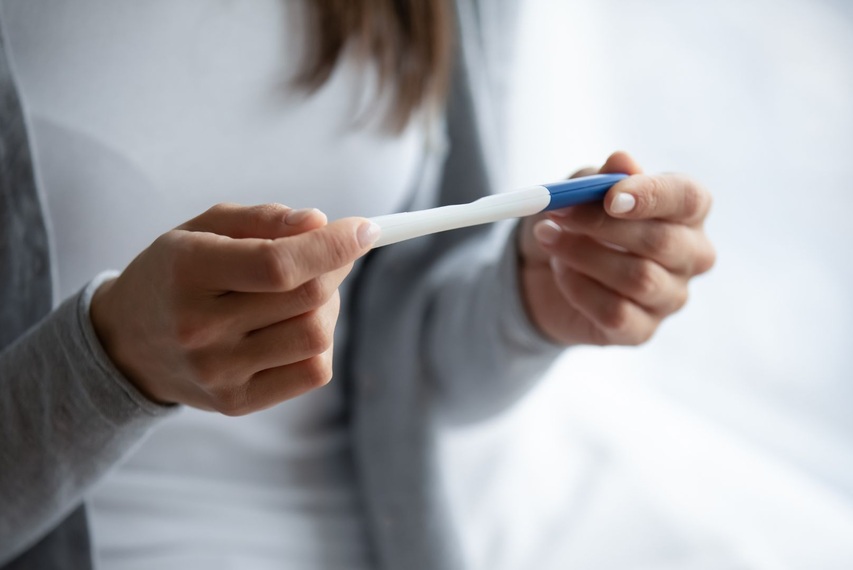 eine Frau hält einen Schwangerschaftstest in den Händen
